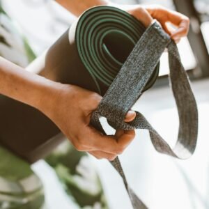 Close-up of a woman's hands holding a yoga mat with a strap. Perfect for fitness and lifestyle concepts.